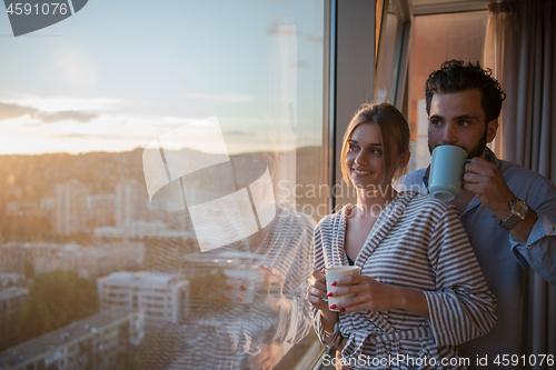 Image of young couple enjoying evening coffee by the window