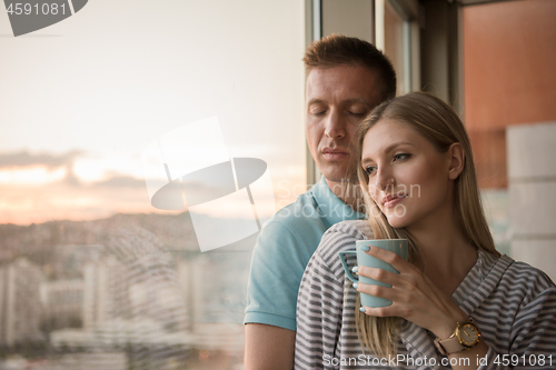 Image of young couple enjoying evening coffee by the window