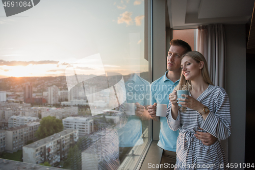 Image of young couple enjoying evening coffee by the window