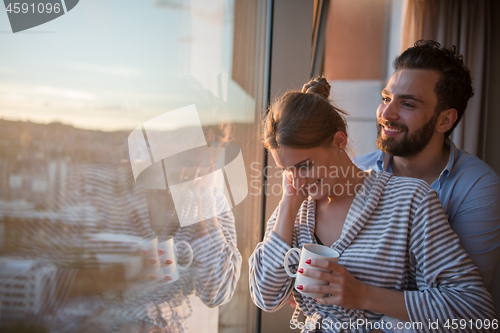 Image of young couple enjoying evening coffee by the window