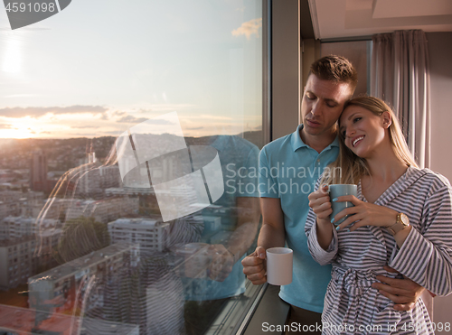 Image of young couple enjoying evening coffee by the window