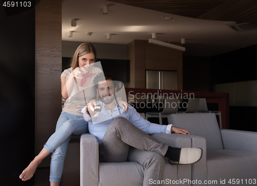 Image of Young couple on the sofa watching television