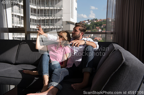 Image of Young couple watching television