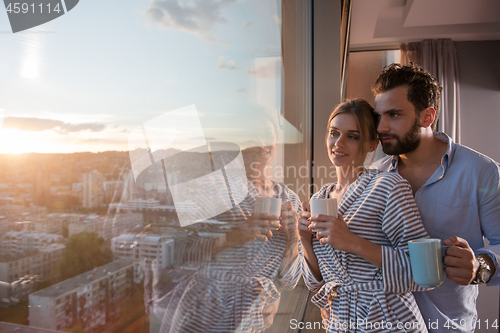 Image of young couple enjoying evening coffee by the window