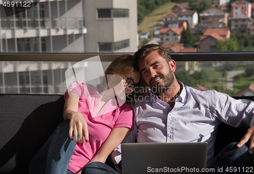 Image of couple relaxing at  home using laptop computers