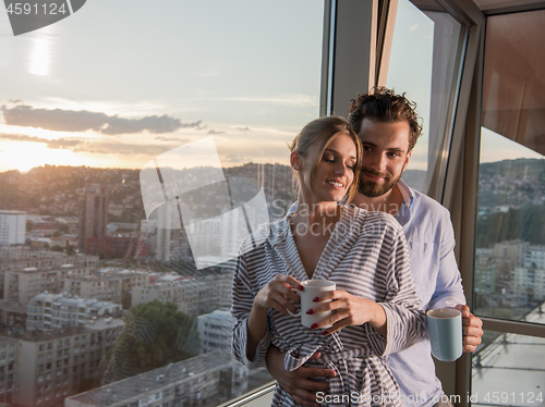 Image of young couple enjoying evening coffee by the window