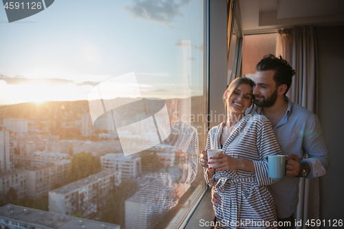 Image of young couple enjoying evening coffee by the window