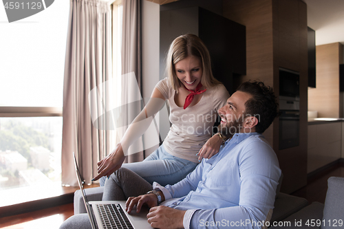 Image of couple relaxing at  home using laptop computers