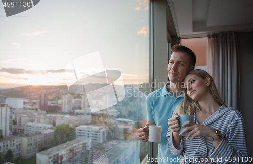 Image of young couple enjoying evening coffee by the window