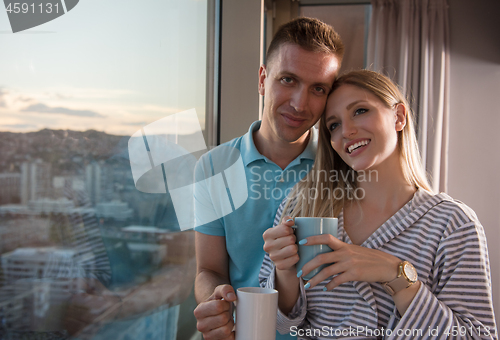 Image of young couple enjoying evening coffee by the window