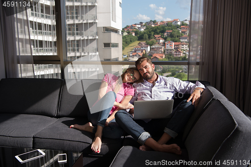 Image of couple relaxing at  home using laptop computers