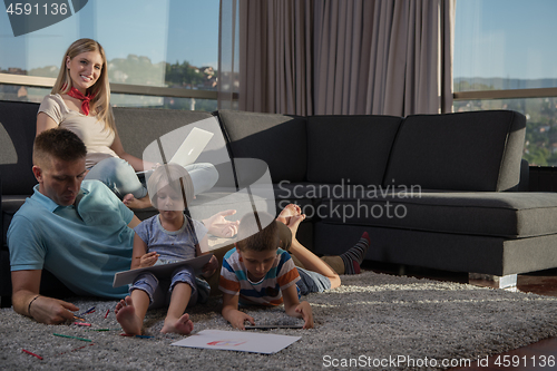 Image of young couple spending time with kids at home