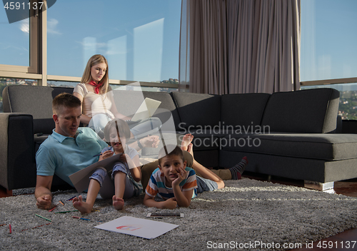 Image of young couple spending time with kids at home