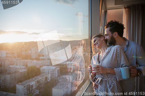 Image of young couple enjoying evening coffee by the window