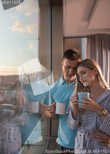 Image of young couple enjoying evening coffee by the window