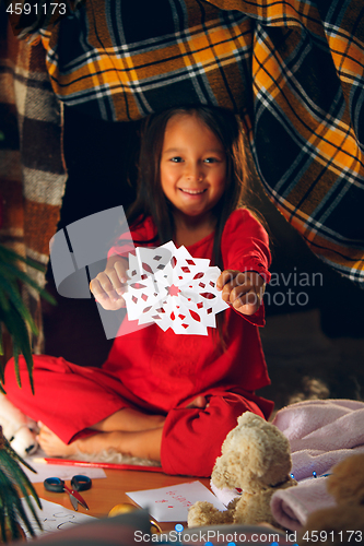 Image of Beautiful girl holding her hands with snowflakes from the paper