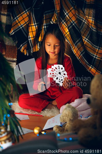 Image of Beautiful girl holding her hands with snowflakes from the paper