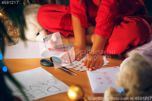 Image of Beautiful girl holding her hands with snowflakes from the paper