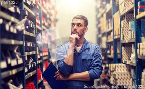 Image of auto mechanic with clipboard at car workshop