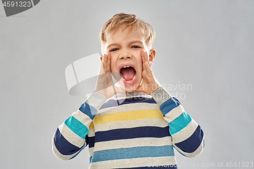 Image of angry little boy in striped pullover screaming