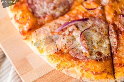 Image of close up of homemade pizza on wooden table