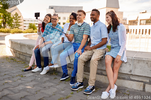 Image of happy friends taking selfie by smartphone in city