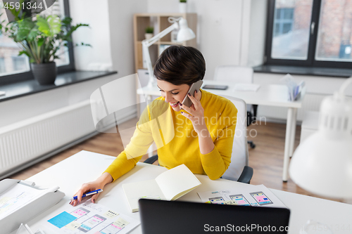 Image of happy ui designer calling on smartphone at office