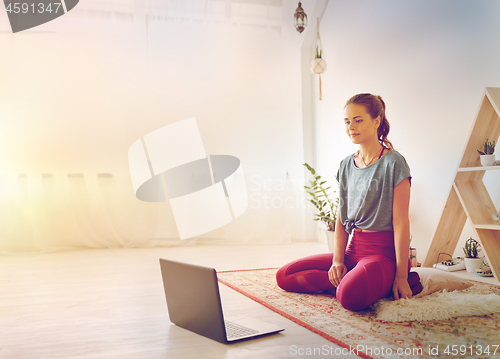 Image of woman with laptop computer at yoga studio