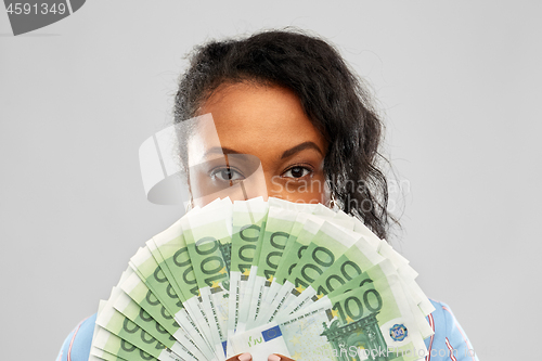 Image of african american woman hiding face behind money