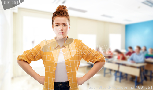 Image of displeased red haired student girl at school