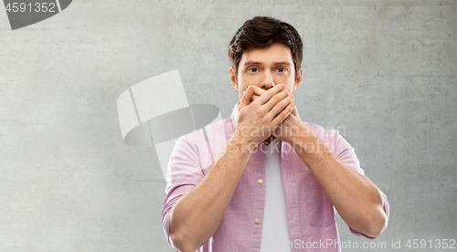 Image of shocked young man covering his mouth by hands