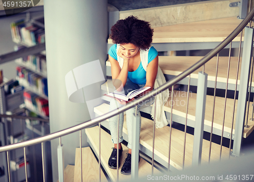 Image of african student girl reading book at library