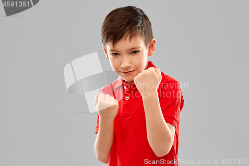 Image of boy in red t-shirt showing fists or boxing