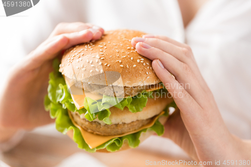 Image of close up of woman holding hamburger