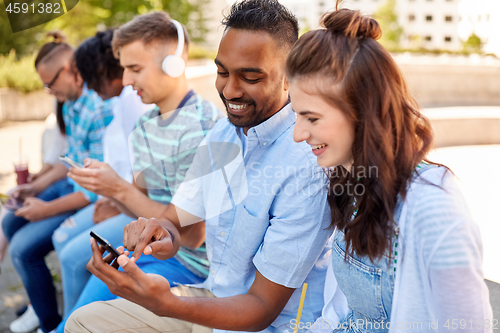 Image of friends with smartphones and tablet pc in city