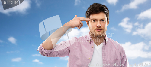 Image of bored man shooting himself by finger gun gesture