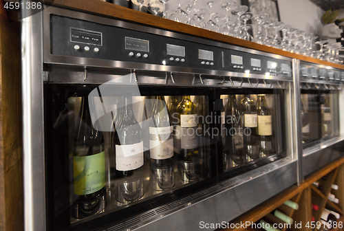 Image of close up of wine bottles in dispenser at bar