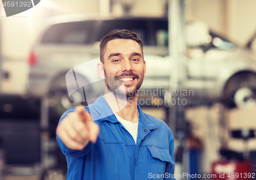 Image of happy auto mechanic man or smith at car workshop