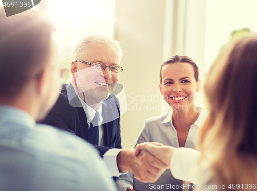 Image of senior businessman making handshake at office