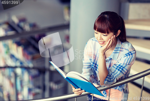 Image of high school student girl reading book at library