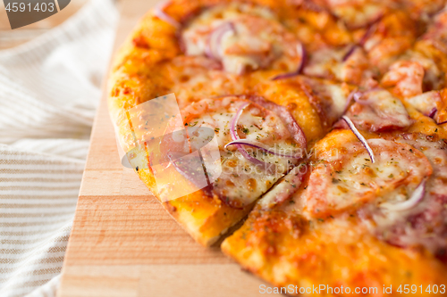 Image of close up of homemade pizza on wooden table