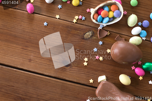 Image of chocolate eggs, easter bunny and candies on wood