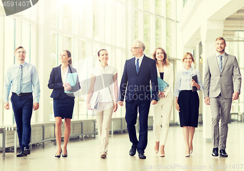 Image of business people walking along office building