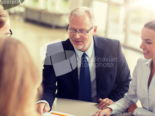 Image of smiling business people meeting in office