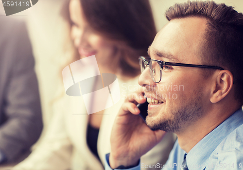 Image of businessman calling on smartphone at office