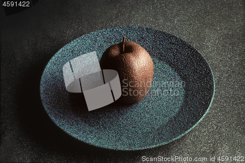 Image of Granite-like sculpture of apple on a plate