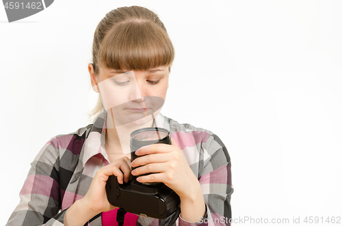 Image of The girl looks sadly at the front lens of the lens on the camera