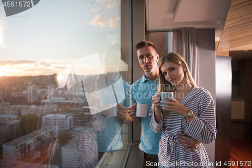 Image of young couple enjoying evening coffee by the window