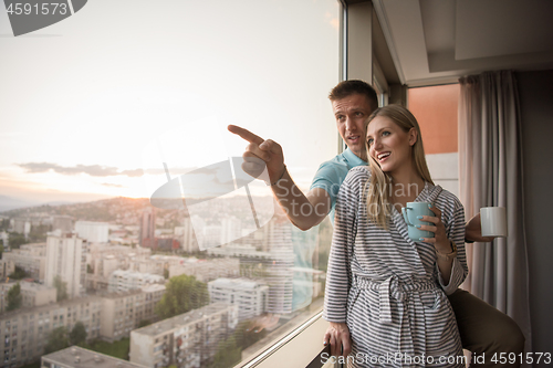 Image of young couple enjoying evening coffee by the window