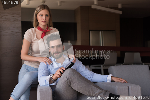 Image of Young couple on the sofa watching television